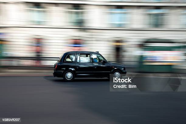 Tradizionale Black Taxi Cab In Accelerazione Giù Street A Londra - Fotografie stock e altre immagini di Londra