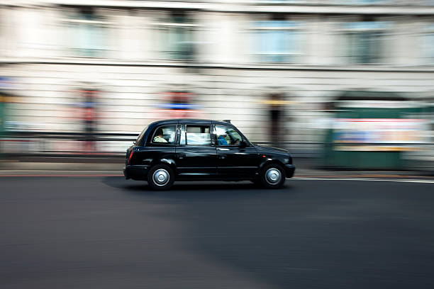 Traditional Black Taxi Cab Speeding Down Street in London London, United Kingdom - October, 1st 2009: A traditional black taxi cab manufactured by LTI (London Taxi International) speeding down street, Park Lane near Marble Arch. Mayfair stock pictures, royalty-free photos & images