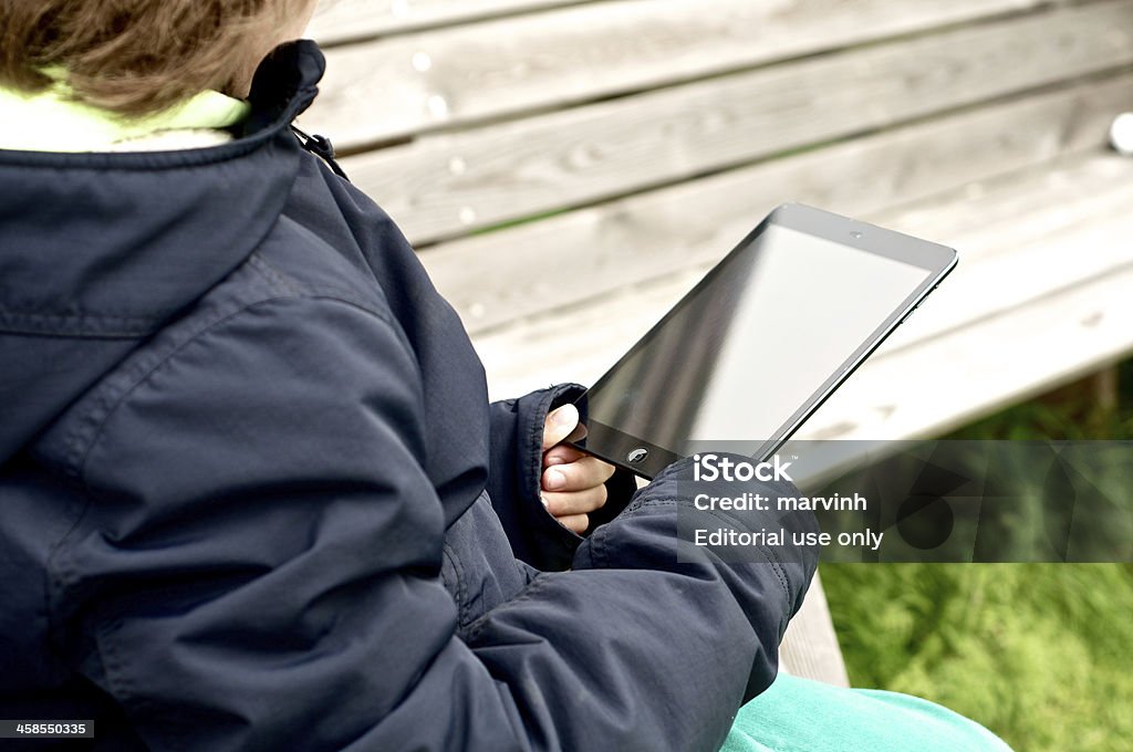 Niño con iPad mini en banco al aire libre - Foto de stock de 8-9 años libre de derechos