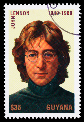 Sacramento, California, USA - April 15, 2011: A 1995 Guyana  postage stamp with a portrait of John Lennon (1940-1980). Lennon was a singer and songwriter, writing or co-writing more than two dozen number one hits, most of them while a member of The Beatles.