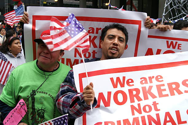Chicago, Illinois, USA - May 01, 2006: A group of protestors gather to protest against immigration reform.A man in a green shirt and a man in a flannel shirt marche and chant down the street in protest. The day was named May Day by protestors.