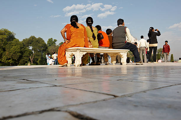 Agra, India - November 18, 2010: Pilgrims sitting on marble bench in grounds of Taj Mahal in Agra, India