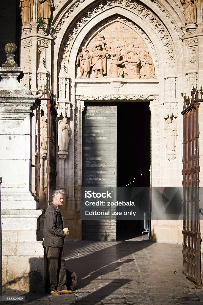 Mendicante sulla parte anteriore della chiesa ingresso, Siviglia - Foto stock royalty-free di 45-49 anni