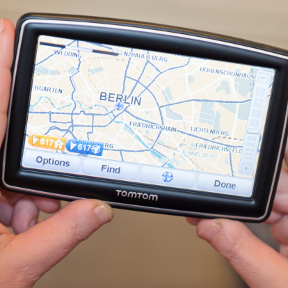 Florence, Italy - March 18, 2011: Woman hand holding a TomTom map with Berlin map. TomTom International BV is a Dutch company that makes satellite navigation systems for automobiles, motorcycles, handhelds and smartphones. Each system has a processor and a touch screen. TomTom is the leading supplier of navigation systems in Europe with offices around the world. The model of TomTom is XXL Europe version with 5 inch screen.