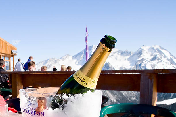 champagne and dining in mountain ski restaurant Courchevel Courchevel 1850, France - February 16, 2008: an uncorked bottle of champagne in an ice bucket on the outdoor terrace of a restaurant high in the mountains of Courchevel 1850 at the top of Chenus. Courchevel 1850 is a popular ski resort in the French Alps with a jet-set image. courchevel stock pictures, royalty-free photos & images