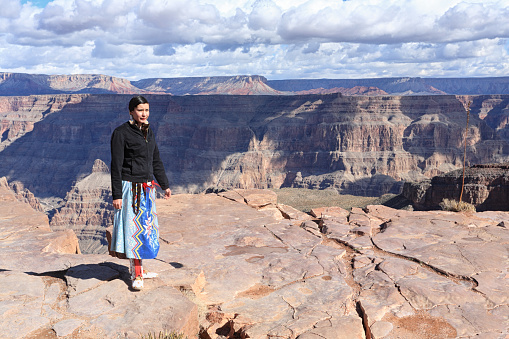 Grand Canyon, Arizona, Usa - January 31, 2008: Young woman, a member of the Hualapai native, standing on the edge of Grand Canyon, West Rim near the famous attraction called the Skywalk