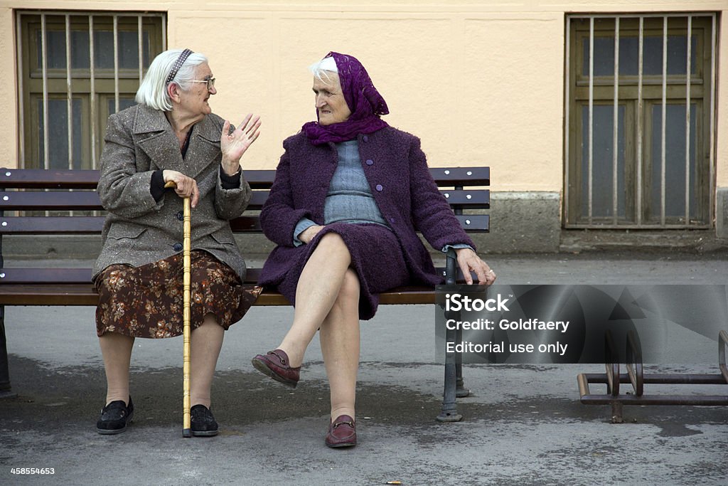 Two old women resting outdoors. Novi Sad, Serbia - April 30, 2011: Two old women resting outdoor, sitting n the bench. Discussion Stock Photo