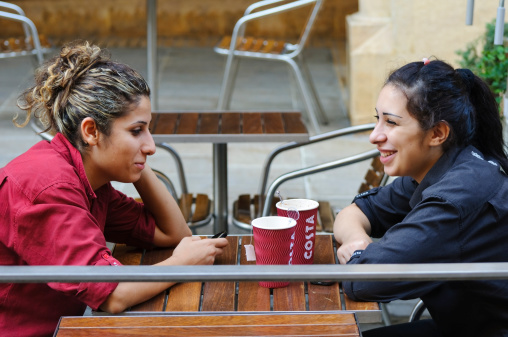 Beirut, Lebanon - September 26, 2010: Two female employees at Costa Coffee sit at an outdoor table during their break. Costa Coffee, founded in 1971, is a British coffeehouse company with locations in more than two dozen countries. It is the second-largest coffeehouse chain in the world, after Starbucks.