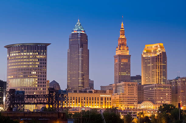 Cleveland Cityscape Just After Sunset With Lights in Buildings Cleveland, Ohio USA - July 16, 2010.  Cleveland Skyline on a summer evening.  View looking Northeast over the Cuyahoga River.  The four tall buikdings are from Right to left are the Federal Courthouse Tower, Key Tower, Terminal Tower, and 200 Public Square (BP Building). terminal tower stock pictures, royalty-free photos & images