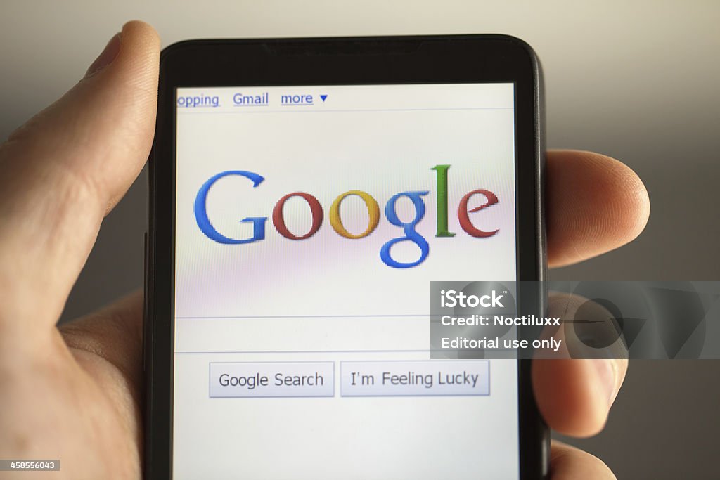 Mano sosteniendo teléfono muestra búsqueda de Google - Foto de stock de Agarrar libre de derechos