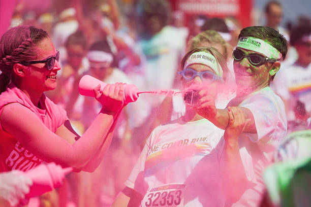 pink powder at the Color Run in Cologne Cologne, Germany - July 21, 2013: competitors at a ColorRun in Cologne, Germany. Color Run is since a few years a world wide upcoming charity event with fun character. The competitors are sprayed with color powder. cologne germany stock pictures, royalty-free photos & images