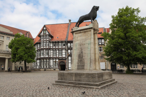 Braunschweig, Germany - May 4, 2011: Unidentified people at Burgplatz (Castle Square) and lion statue, heraldic animal of Braunschweig, Germany.