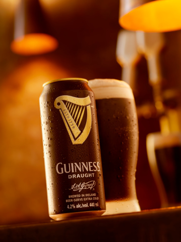 Calgary, Canada - April 5, 2011: Ice cold Can and Pint of Guinness Beer shot in a Bar Setting, Guinness is Brewed in Ireland