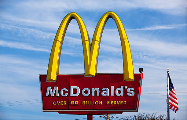Nashua, New Hampshire, USA - April 14, 2011: McDonald's sign and the American flag. McDonald's is the world's largest chain of hamburger fast food restaurants.