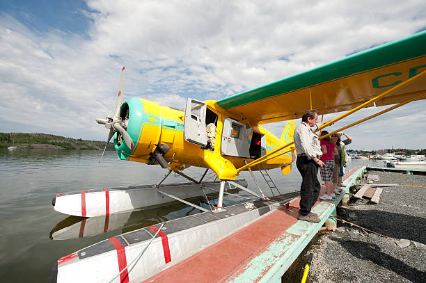 Arctic Float Plane. Yellowknife, Canada - July, 25 2009: A pilot waits to load passengers for a sight seeing flight around the Yellowknife area in his float plane.  The aircraft is a Norseman from the 1930s era. great slave lake stock pictures, royalty-free photos & images