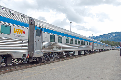 Jasper, Alberta - May 6, 2011: The cars of a Canadian VIA Rail passenger train at the train station in Jasper, Alberta. Jasper is in the Rocky Mountains. Via Rail is a government operated train in Canada. There are 480 VIA trains operating in the provinces with the main office in Montreal, Quebec.