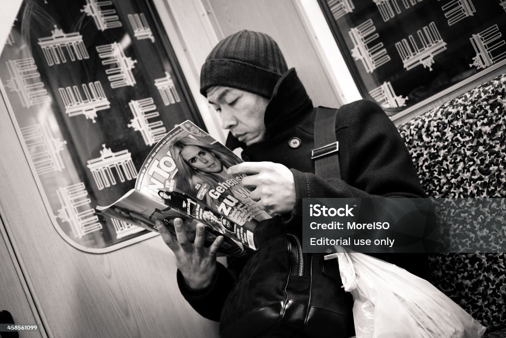 Man reading on the UBahn in Berlin Berlin, Germany - January, 23 2010: a man reads a magazine while sitting in the U-Bahn U5 train in Berlin. Magazine - Publication Stock Photo