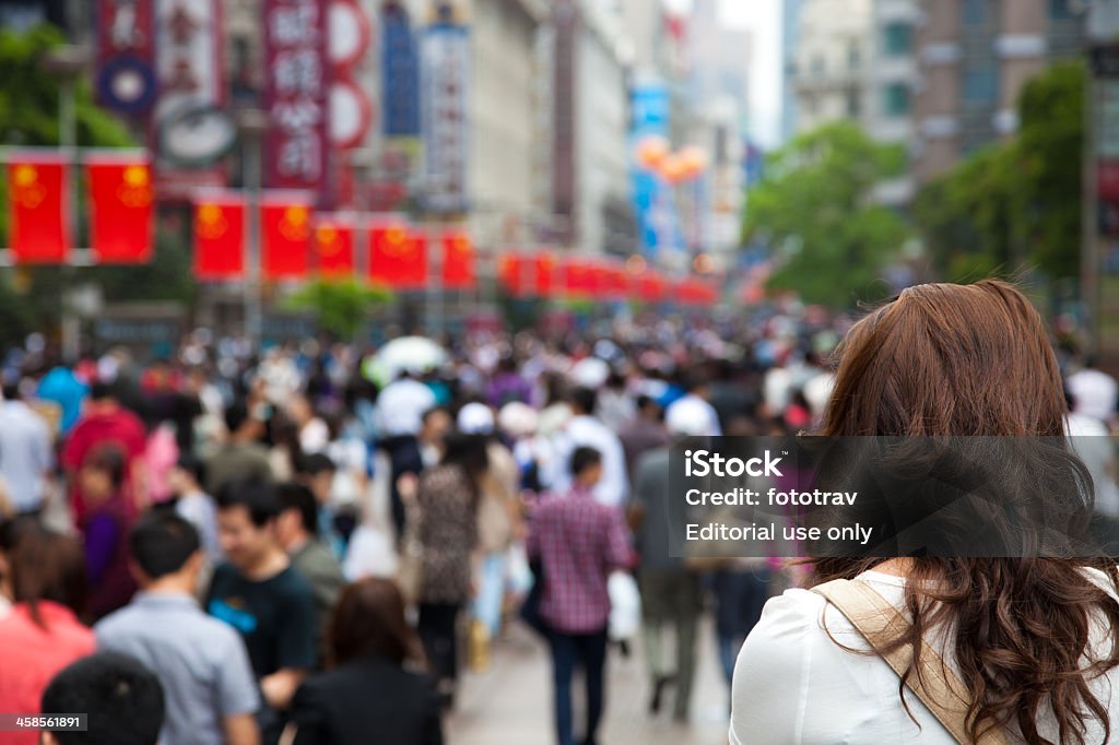 Chinese girl standing in front of a crowd, Shanghai, China - Foto de stock de Abundancia libre de derechos