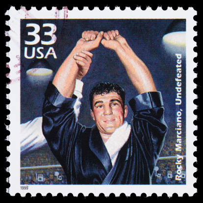 Sacramento, California, USA - March 20, 2011: A 1999 USA postage stamp with an illustration of boxer Rocky Marciano raising his hands in victory in a boxing ring. Marciano (1923-1969) is the only heavyweight champion boxer to retire undefeated.