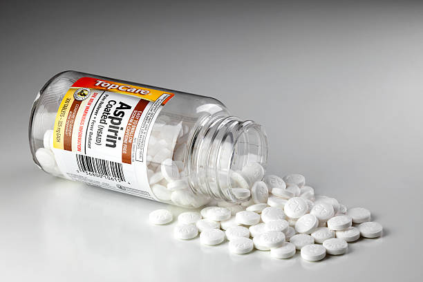 Aspirin bottle with tablets spilling out stock photo