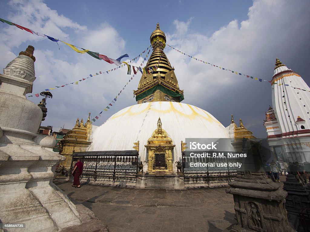 Swayambhunath Stupa, Also Known as Monkey Temple in Kathmandu, Nepal Kathmandu, Nepal - March 9, 2013: A Buddhist monk walking around the ancient Swayambhunath stupa, an important pilgrimage site for both Buddhists and Hindus in Kathmandu, Nepal. Adventure Stock Photo