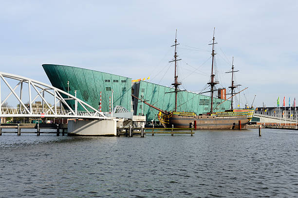 Amsterdam, the Netherlands - April 2, 2011: Museum NEMO with a replica of VOC ship aEThe Amsterdamaa, next to Amsterdam Central Station along the river IJ. NEMO is the largest science center in the Netherlands. Everything in NEMO is related to science and technology. aEThe Amsterdamaa was a 18th century cargo ship of the Dutch East India Company and was wrecked only 18 days after its first voyage. The replica was built between 1985 and 1990 by 400 volunteers with tools of the time. Usually the ship is moored next to the Netherlands Maritime Museum, but while that museum is undergoing renovations, it is moored next to NEMO. The ship can be visited.