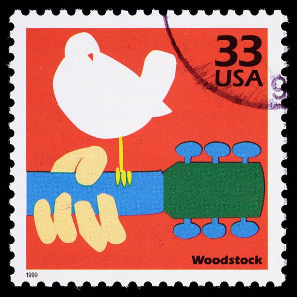 USA Woodstock postage stamp Sacramento, California, USA - March 28, 2011: A 1999 USA postage stamp with the Woodstock Music and Art Festival logo. The music festival was held from August 15-18, 1969, and became an identifying cultural event for a generation. Woodstock and the Woodstock logo are registered trademarks of Woodstock Ventures, Inc. woodstock stock pictures, royalty-free photos & images