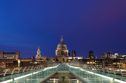 London, United Kingdom - April 2, 2011: Long exposure of St. Paul's Cathedral taken from the Millennium bridge at dusk. The Millennium bridge is a pedestrian steel suspension bridge that links Bankside to 'The City', London's traditional financial centre. St Paul's Cathedral is one of the world's most famous churches as well as one of London's most recognisable landmarks.