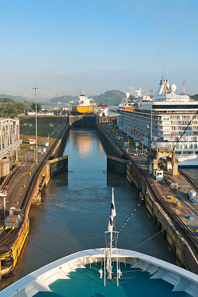 PANAMA CANAL, PANAMA - March 11, 2011: Ships traversing the Miraflores Locks, Panama Canal.  These locks are raising the ships to the level of the Mirafores Lake. The Panama Canal acts as a shortcut, replacing the dangerous trip around the southernmost tip of South America. A ship sailing from New York to San Francisco via the canal cuts the travel distance more than in half.