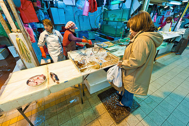 Hong Kong, China - January 17th, 2011: Woman buying fresh fish from a seafood stall at a market in Mong Kok, Kowloon.