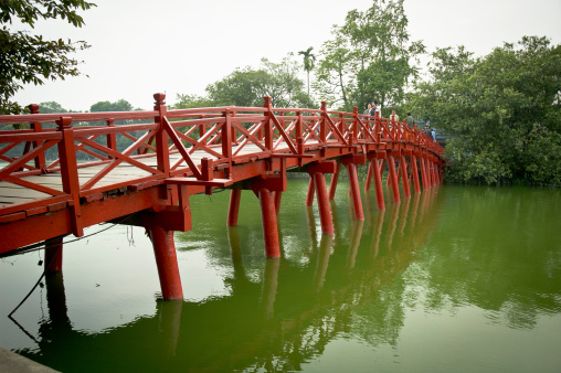 Hanoi, Vietnam - December 13, 2006: The Huc Bridge sits on Hoan Kiem Lake in the centre of Hanoi, Vietnam. The bridge leads to Ngoc Son Temple which sits on a small island in the lake. The lake and bridge have become a popular tourist destination.