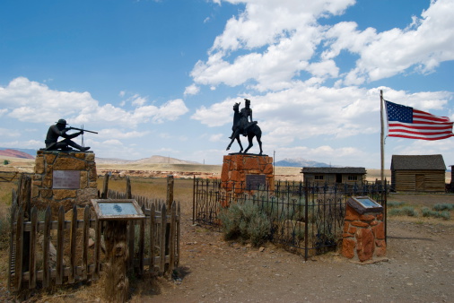 Cody, Wyoming, USA - July 30, 2008: Bronze statue of Liver-Eating Johnson erected over his grave at Old Trail Town, where there are also a collection of historic western buildings and artifacts.