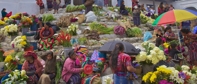 Chichicastenango, Guatemala - April 19, 2012 : Mayan women and children selling flowers on the steps of the Saint Thomas Church.