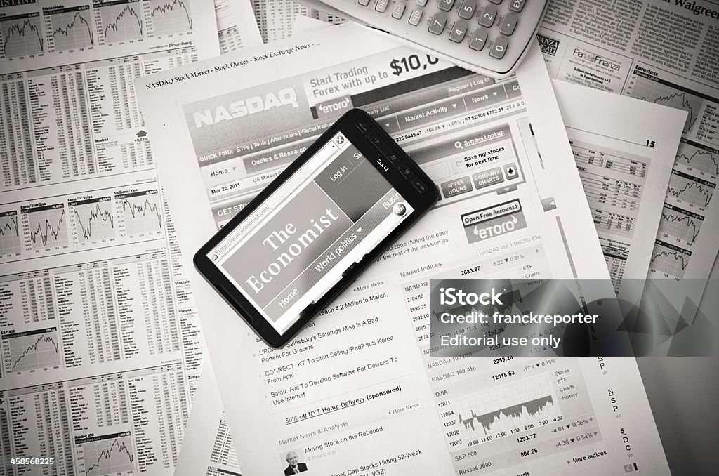 www.economist.com auf HTC smart phone und finanzielle Zeitung - Lizenzfrei .com Stock-Foto