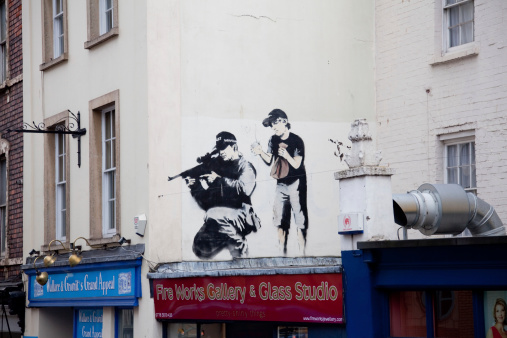 Bristol, United Kingdom - March 29, 2011: Banksy graffiti on the wall in central Bristol. Banksy is an anonymous English graffiti artist, political activist, film director and painter.