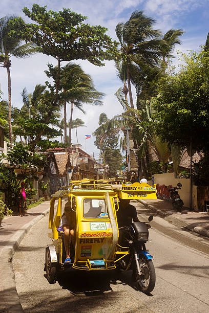 Boracay - Philippine Tricycle Boracay, Philippines - September 18, 2013: A motorised tricycle travels beneath palm trees along Main Road, Boracay Island. Tricycles are a common means of passenger transport everywhere in the Philippines. philippines tricycle stock pictures, royalty-free photos & images