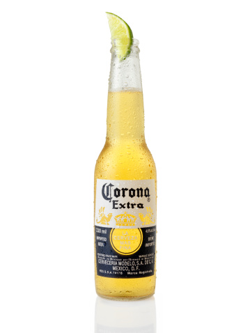 Calgary, Canada - April 4, 2011: Ice Cold Bottle of Corona Beer with a Lime, shot in Studio on white with Natural Reflection, Corona is an Imported Beer from Mexico