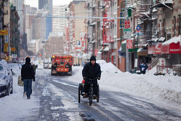 New York, USA - December 27, 2010: Man pedals a trishaw in Chinatown\\'s street, the day after snow blizzard at the end of 2010.