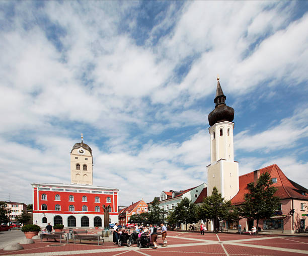 Erding, Germany - June 21, 2013: Church and Old Town Hall in the center of Erding in Germany. At the square there is a family. They are going to a party. Most of them wearing traditional bayerische clothes.
