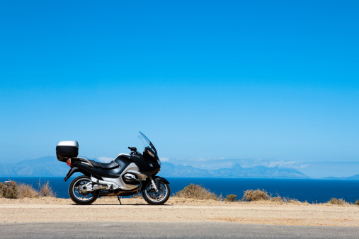 Cape Town, South Africa - January 30, 2011: 2006-model BMW R1200RT motorcycle near Cape Town, South Africa. Luxury touring motorbike, flagship of the BMW Motorrad range, parked beside a scenic coastal road in a popular tourist area.