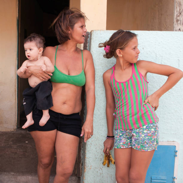 Fortaleza, Brazil - November 14, 2011: Slum houses and local people in slum area of Fortaleza. A favela is the generally used term for a shanty town in Brazil. People are living infront of their houses, talking to their neighbours is part of their social life.