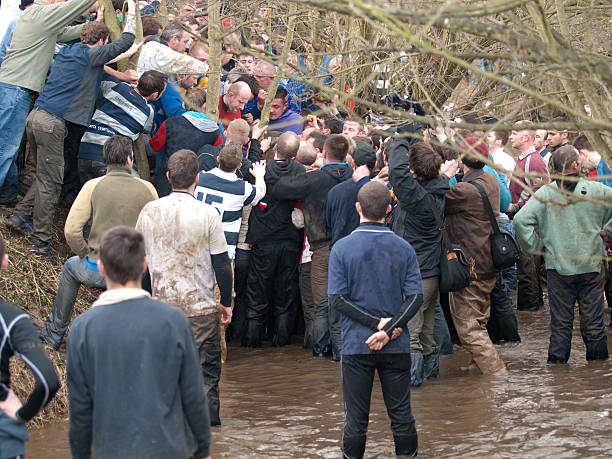 Ashbourne, Derbyshire, UK- March 9 2011: The hug or fight for the ball in the Shrovetide football match going on in the river. The aim of the game is to move the ball about a mile and a half in either direction from the start point to the goal. Progress of the ball can be very slow, but runners wait on the edge of the hug in case the ball is ejected, in which case the game moves very quickly to another location in the town.