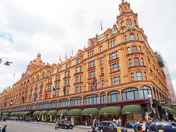 Harrods, London London, United Kingdom - May 21, 2009 : Front view of Harrods Building and the street full of people and black taxi cars harrods photos stock pictures, royalty-free photos & images