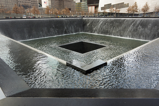 New York, United States - January 13, 2012: The World Trade Center memorial in New York. It will be part of the new World Trade Center complex with four more skyscrapers and a memorial to the September 11th attacks in 2001. The names of the 2977 victims of the attack on 2001 and also those killed on the 1993 attack are engraved in stone around the pool  that were placed were once the towers stood.