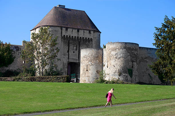 Caen, Normandy, France - September 29 2011: A woman in pink walking in front of the Ducal Castle of Caen.