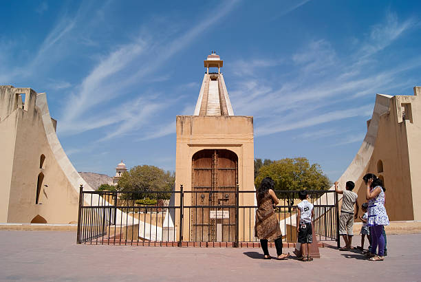 Jaipur, India - March 21, 2011: A group of visitors to the Jantar Mantar observatory stand before a giant sundial called the samrat yantra. The world\\'s largest sundial, it was first built around 1727, and astronomers still use it to predict the weather for farmers.