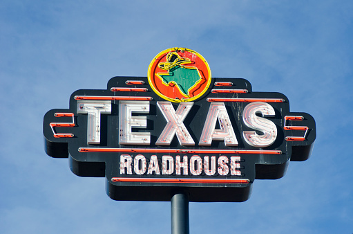 Colorado Springs, United States - November 17, 2011: A Texas Roadhouse restaurant is easy to locate because of this neon sign, photographed against a blue sky, with plenty of copy space available.