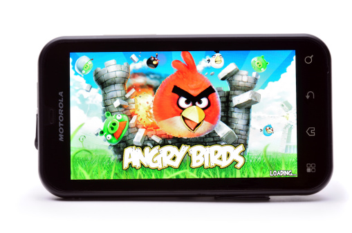 Tokmak, Ukraine - April 3rd, 2011: Motorola Defy smart phone isolated on white background showing puzzle video game Angry Birds. This game one of the great hits of 2010 with 100 million downloads across all platforms