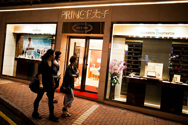 femme passant devant le magasin de montre de luxe - shopping jewelry chinese ethnicity asian ethnicity photos et images de collection