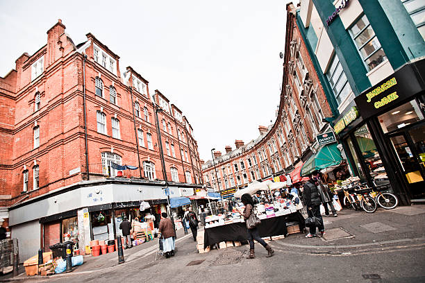 London, UK - May 5, 2011: People walking at Brixton street market, just behind railway station.